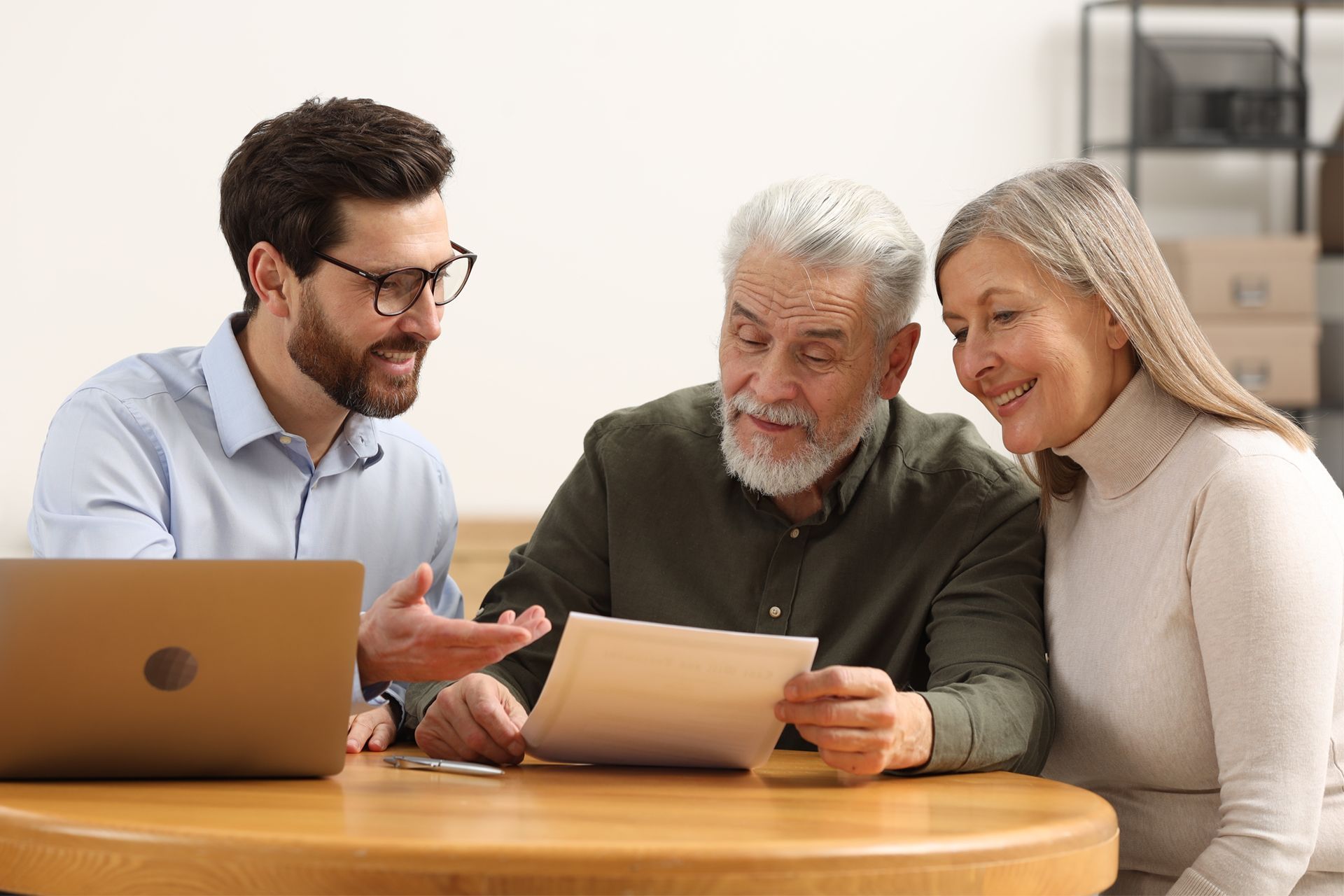 Real estate agent reviewing documents with a smiling senior couple.