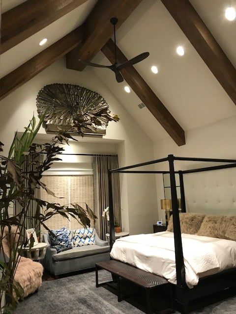 Bedroom with high, vaulted ceiling, exposed wooden beams, and a four-poster bed.