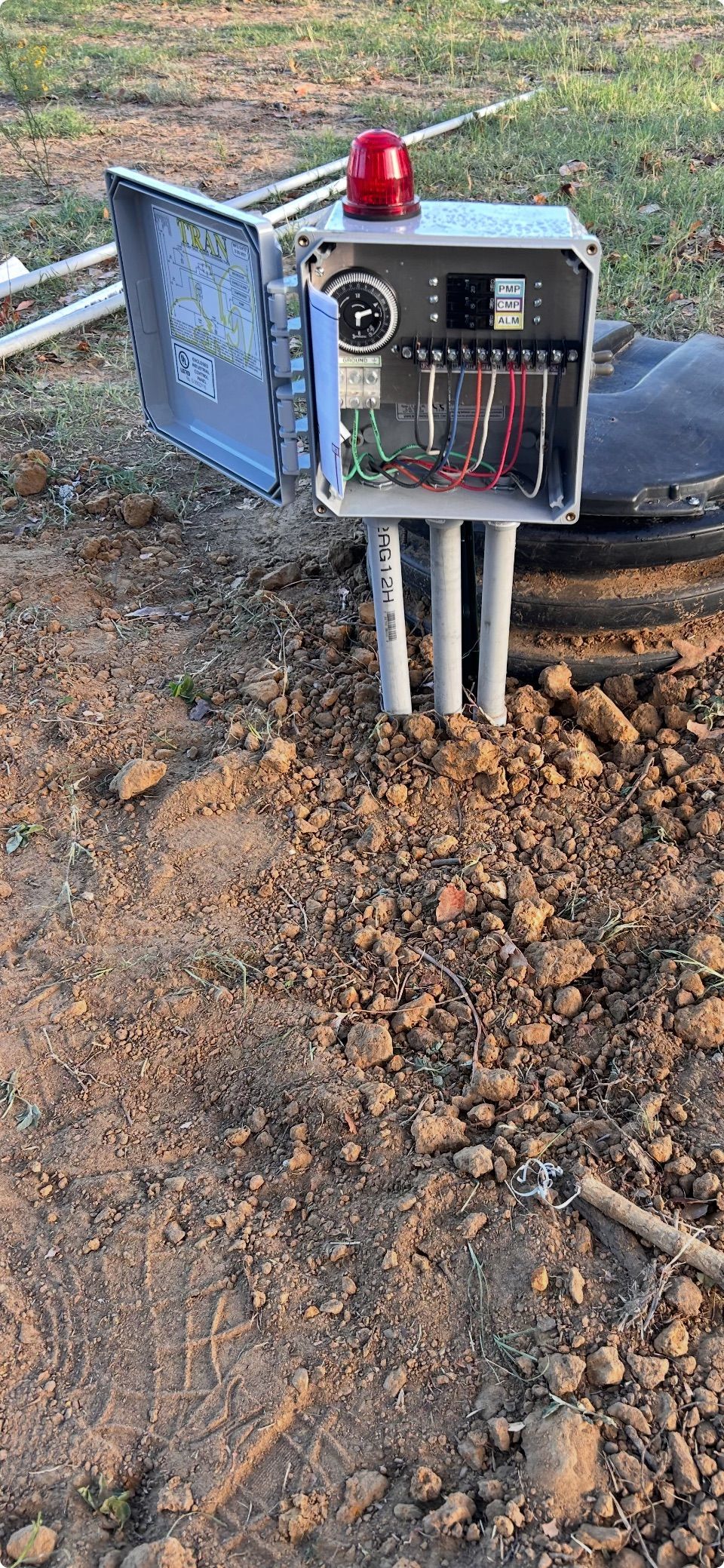 A box with a red light on top of it is sitting on the ground.