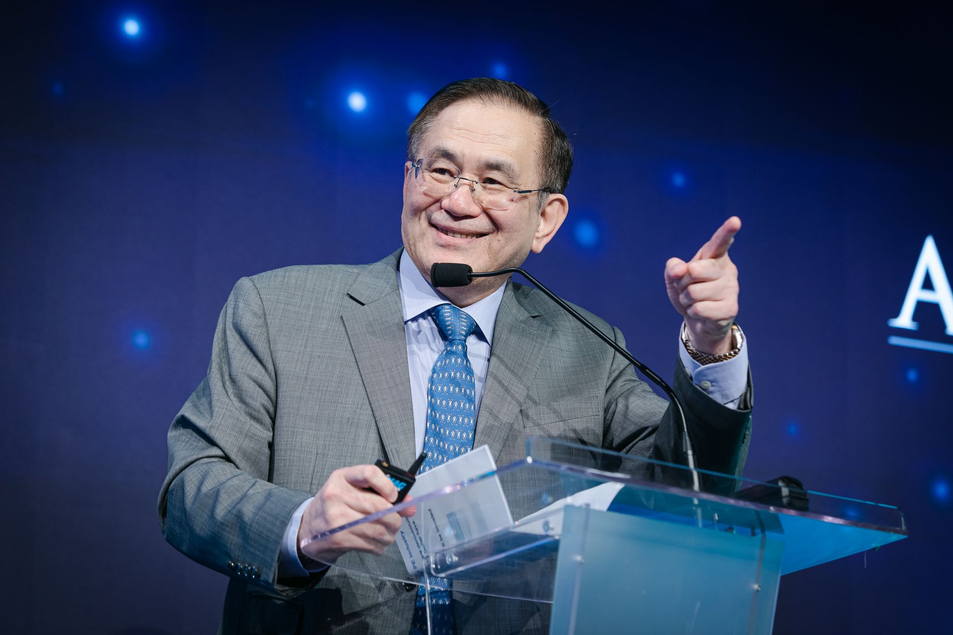 A photo taken by Ash Garwood of a man talking to a panel at a town-hall style corporate event.