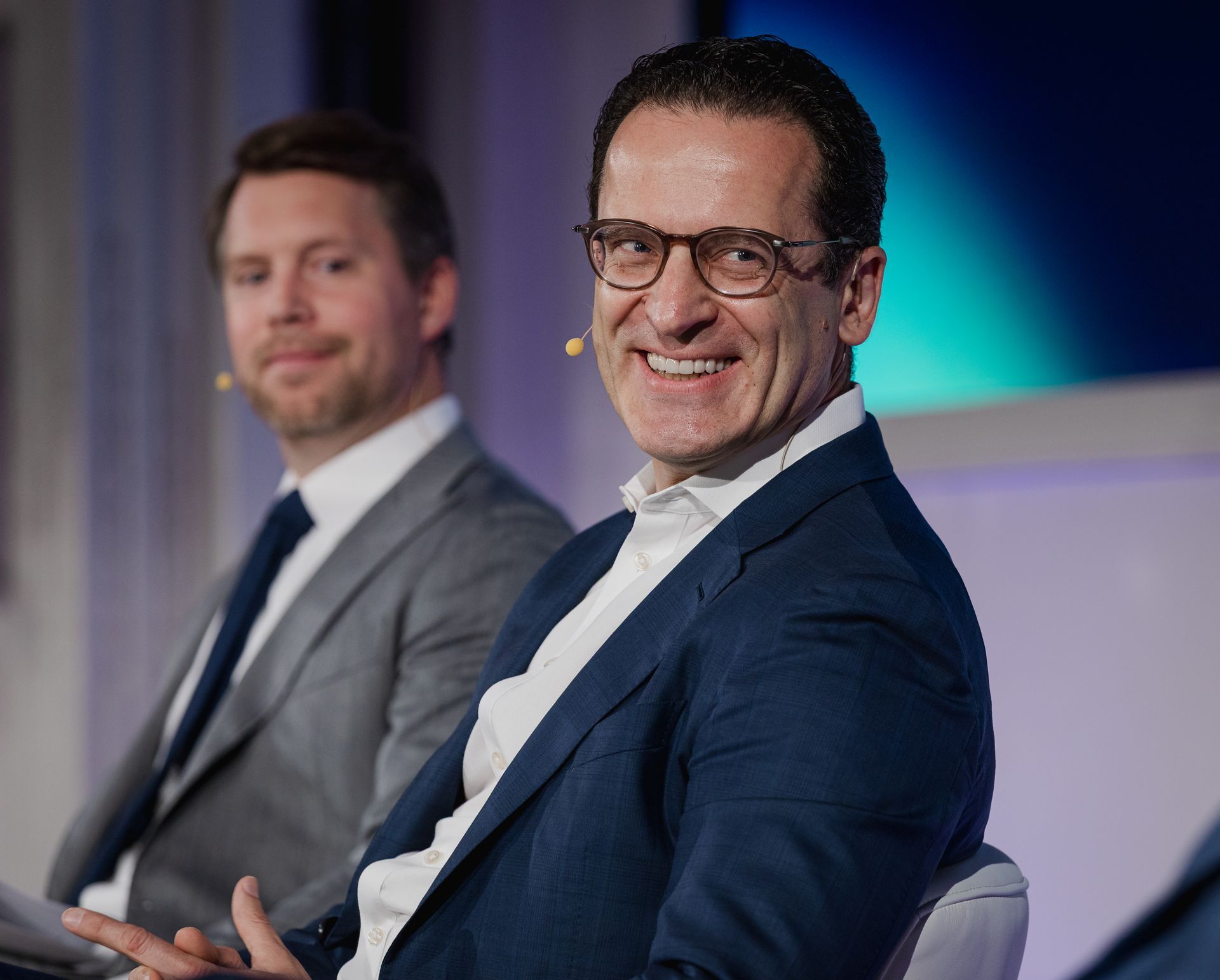 A photo taken by Ash Garwood of a man talking to a panel at a town-hall style corporate event.
