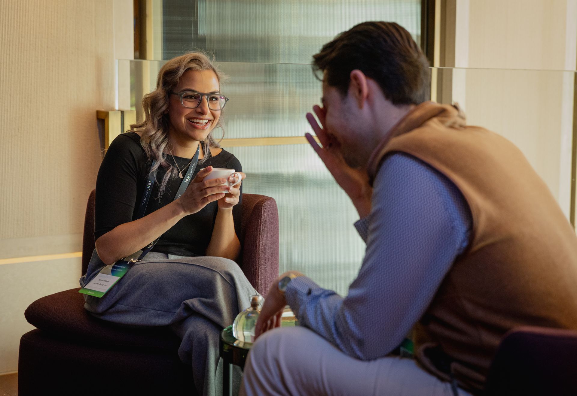 A photo taken by Ash Garwood of a man and woman at a corporate event, candidly talking with each other.