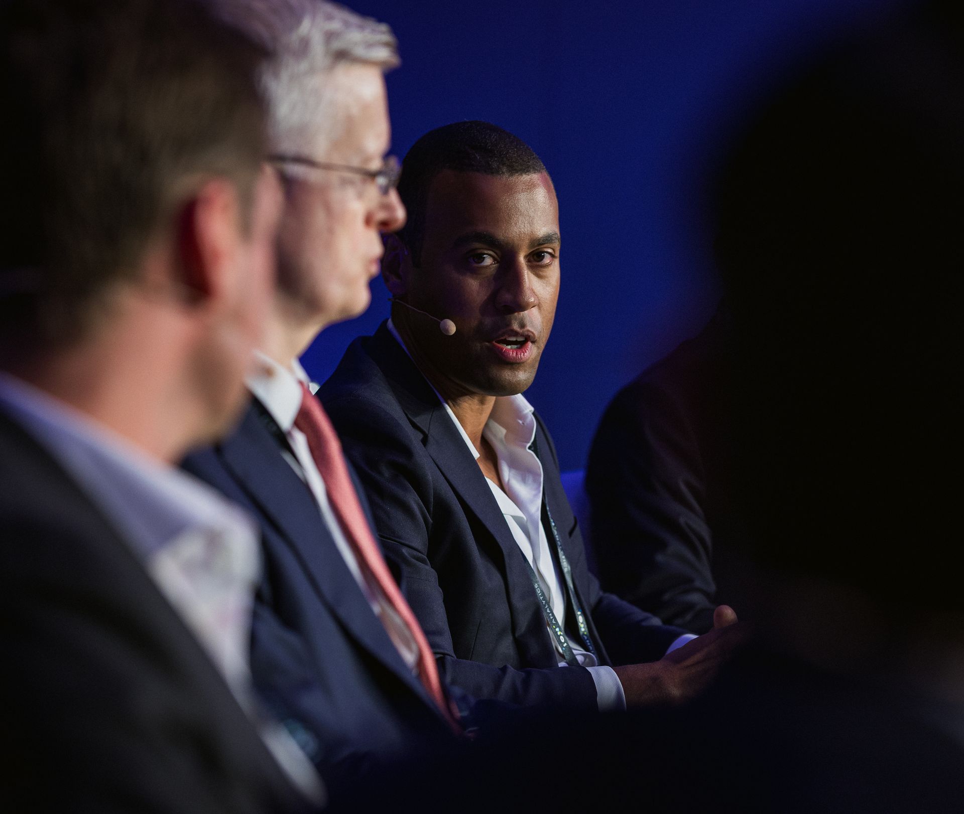 A photo taken by Ash Garwood of a man talking to a panel at a town-hall style corporate event.