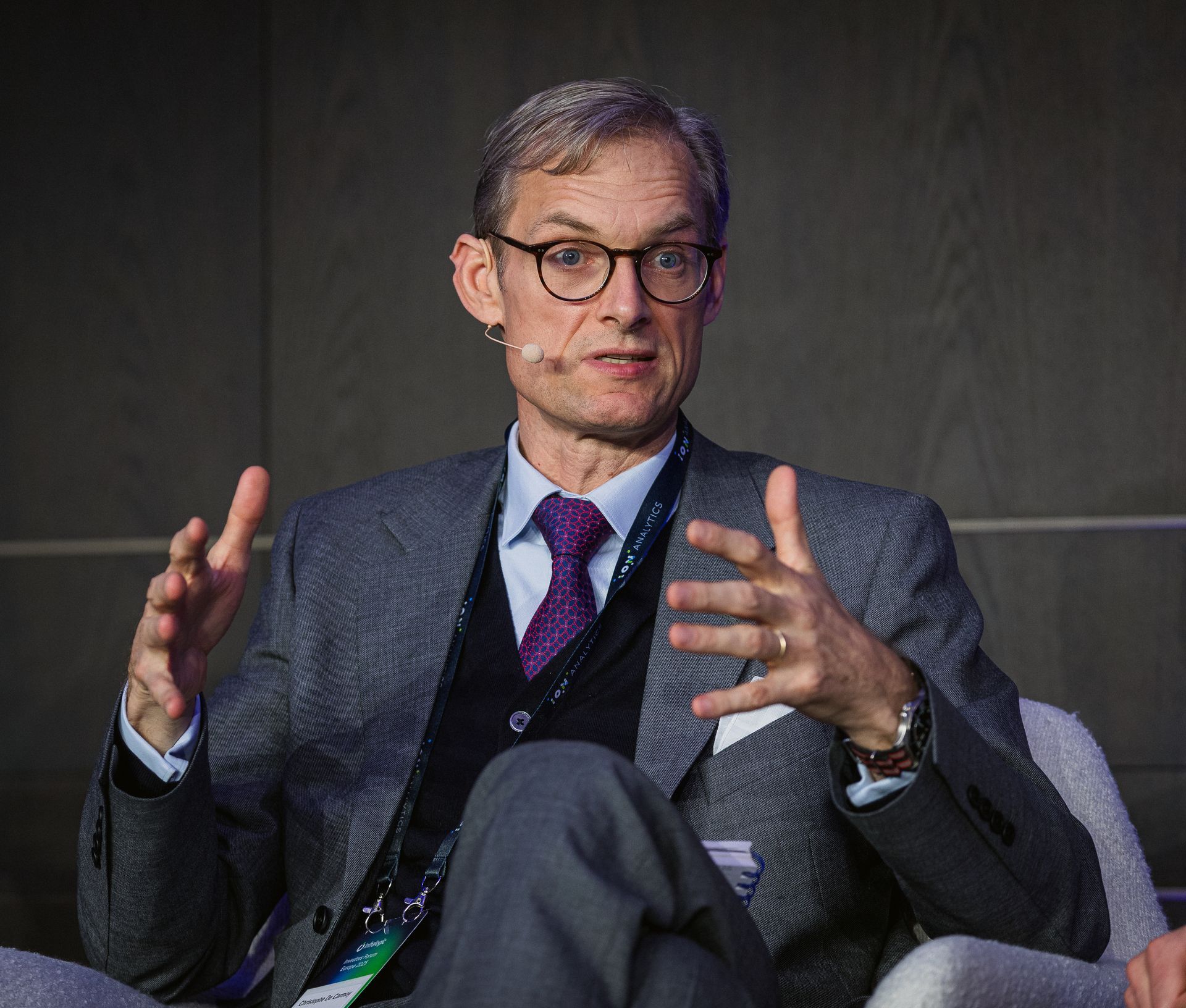 A photo taken by Ash Garwood of a man talking to a panel at a town-hall style corporate event.