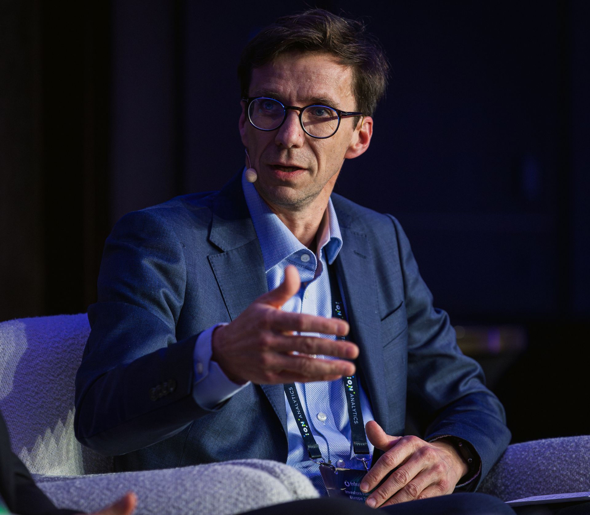 A photo taken by Ash Garwood of a man talking to a panel at a town-hall style corporate event.