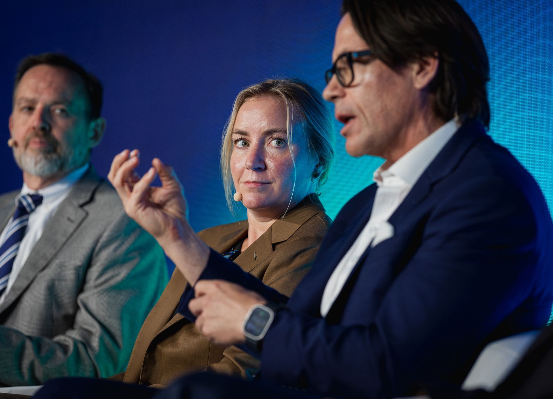 A photo taken by Ash Garwood of a woman listening to a panel at a town-hall style corporate event.