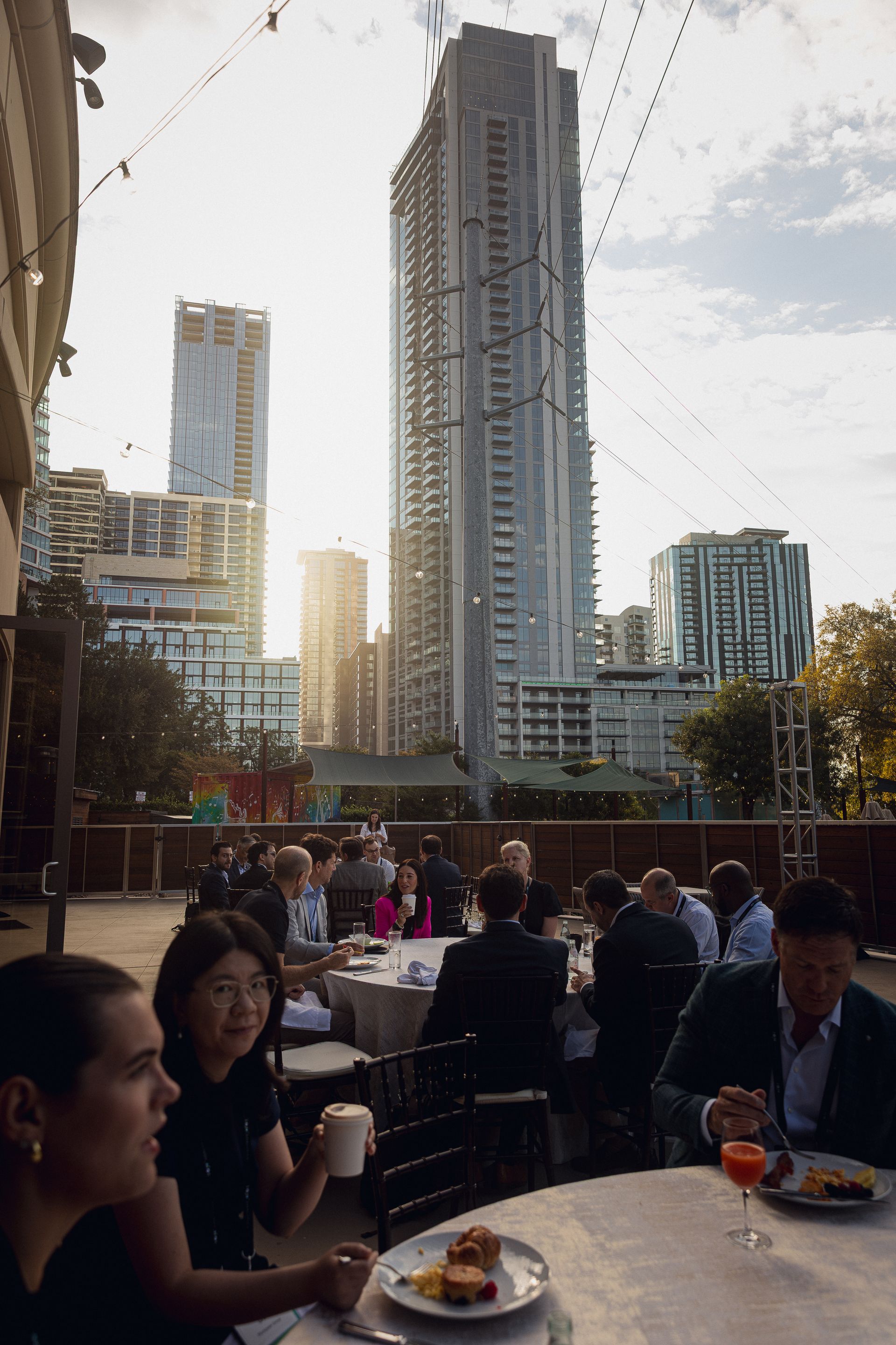 A photo taken by Ash Garwood of a group of people outside of a corporate gala with a view of downtown Austin, Texas