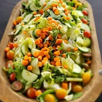 Three shrimp tacos with toppings, served on a stand, with lime wedges and a side of salsa.
