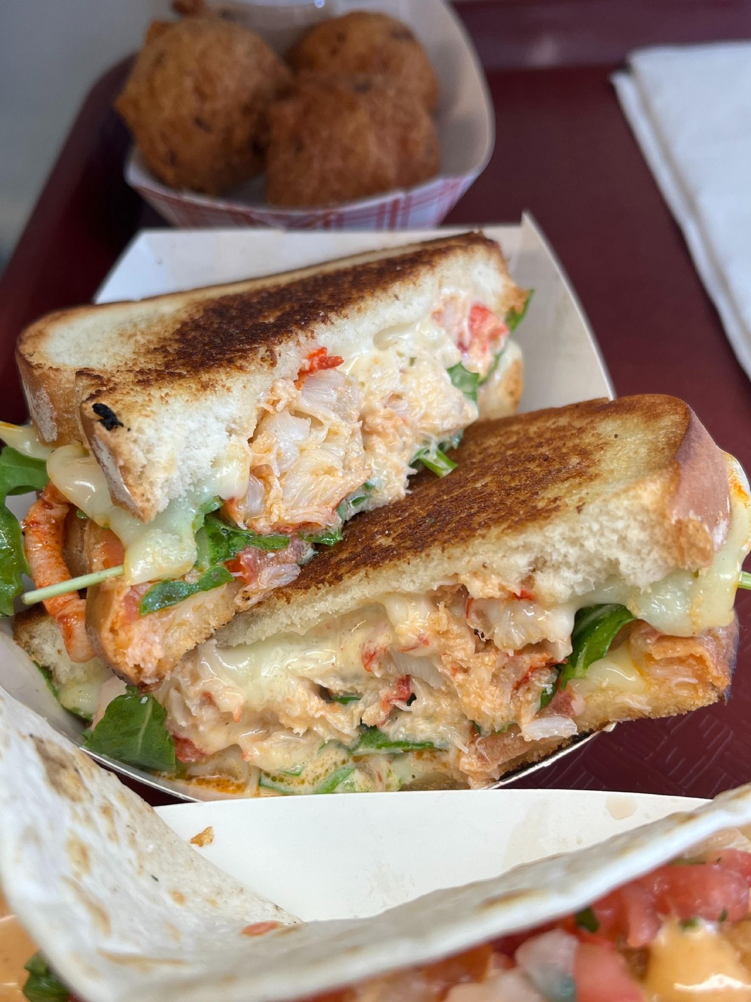 Lobster grilled cheese sandwich with arugula, two hushpuppies.