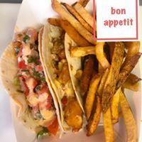 Tacos with french fries. One with sauce, the other with filling.