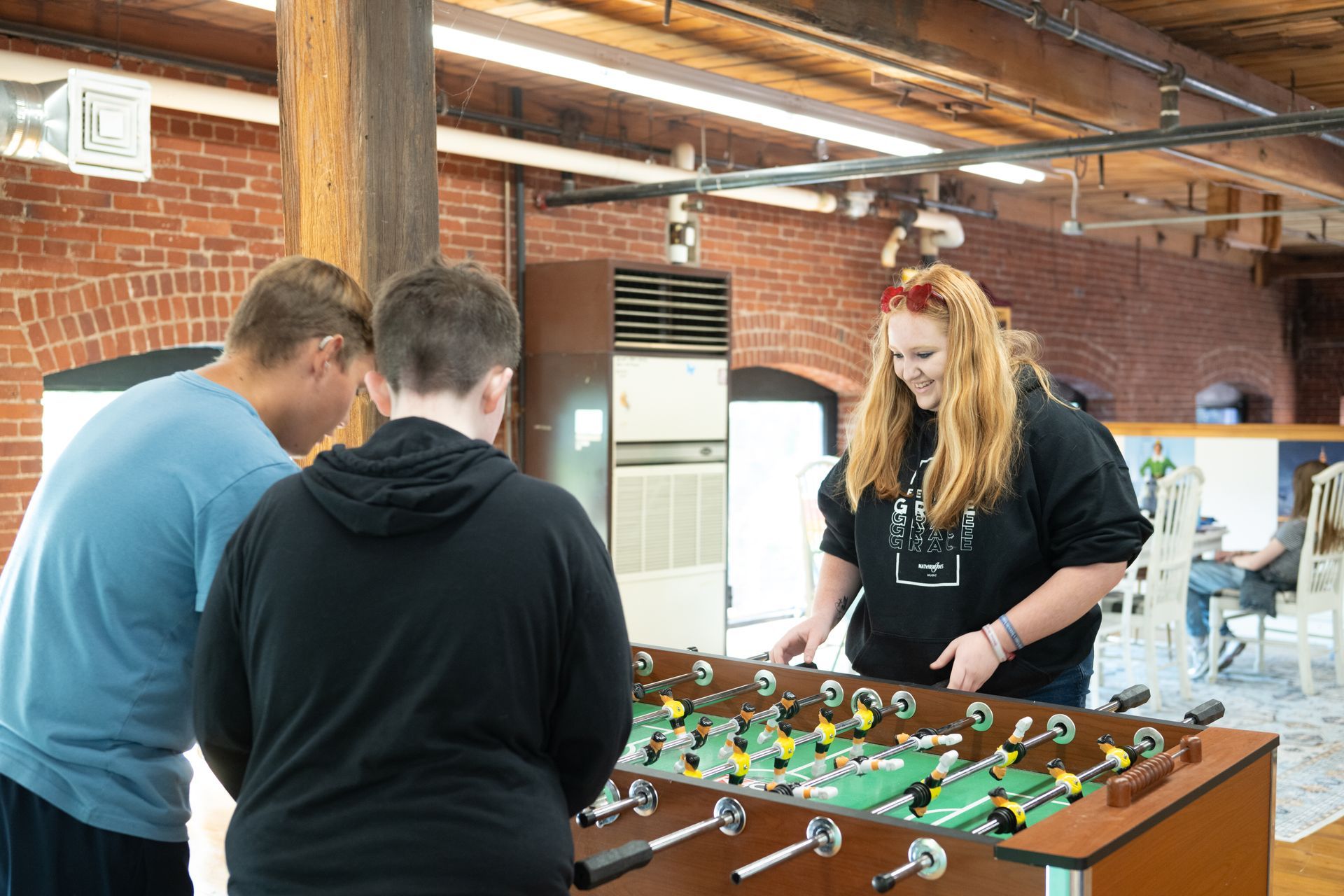 A group of people are playing foosball in a room.