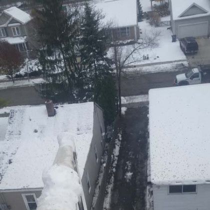 An aerial view of a snowy neighborhood with houses covered in snow.