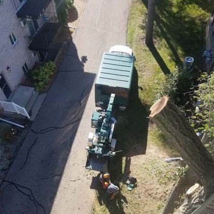 An aerial view of a tree stump being removed by a truck.