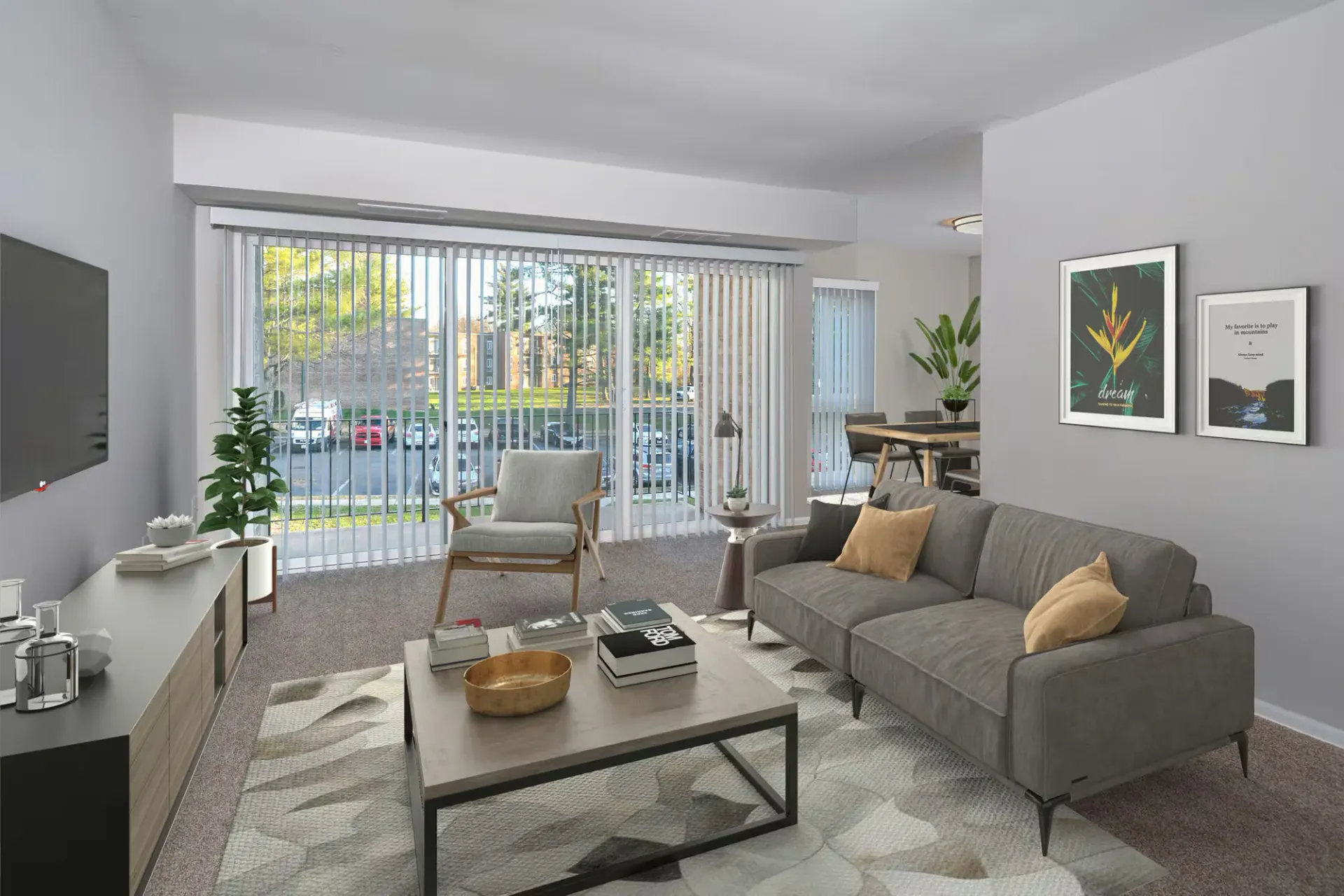 Living room in an apartment with a gray sofa, armchair, coffee table, and large windows with vertical blinds at Metro Pointe in Baltimore, MD.