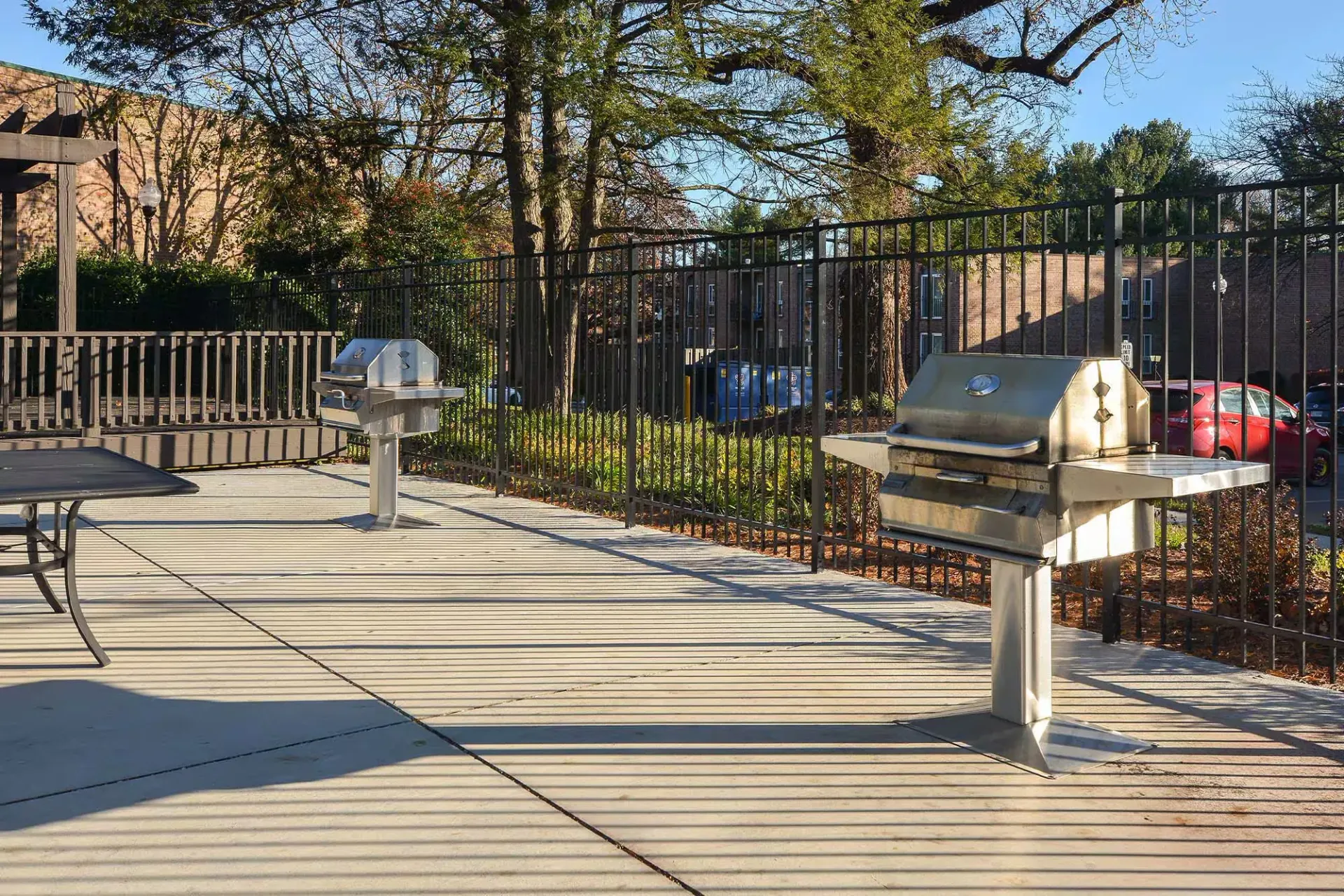 Outdoor community grilling area with two stainless grills and a table at Metro Pointe in Baltimore, MD.