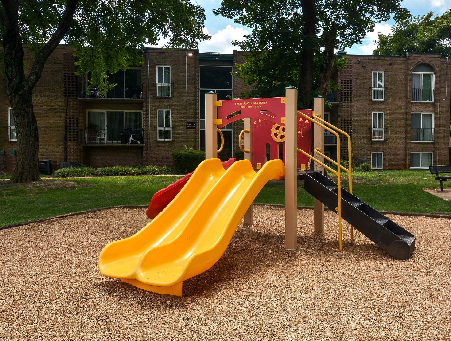 Playground with yellow slides in an apartment complex courtyard at Metro Pointe in Baltimore, MD.