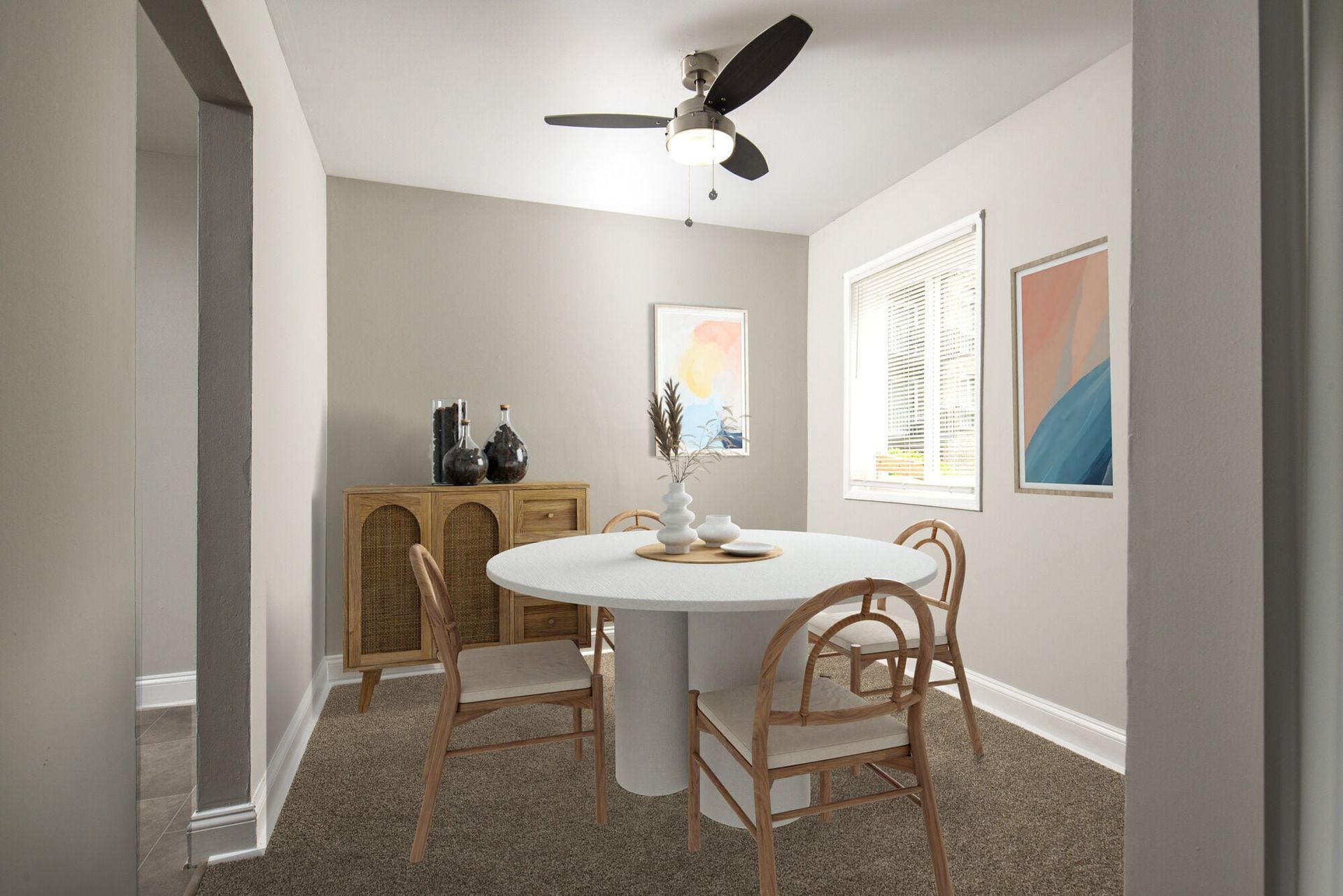 Dining area with round white table, four light wood chairs, and neutral decor at Metro Pointe in Baltimore, MD.
