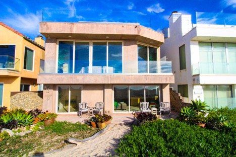 house on the beach with bushes in the front