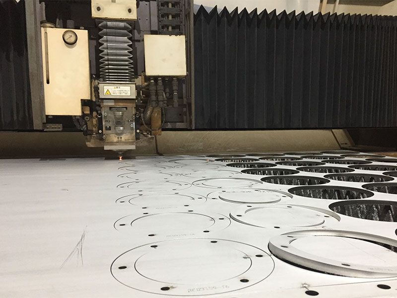 A machine is cutting a piece of metal on a table.