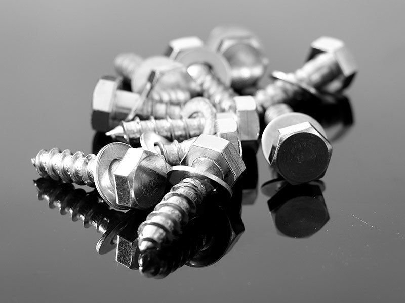 A bunch of screws and nuts on a black surface
