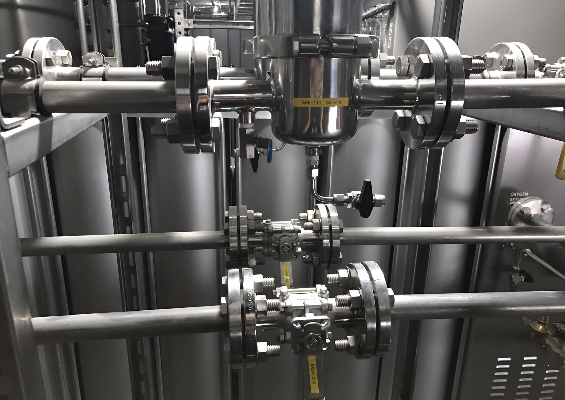 A close up of a stainless steel pipe system in a factory
