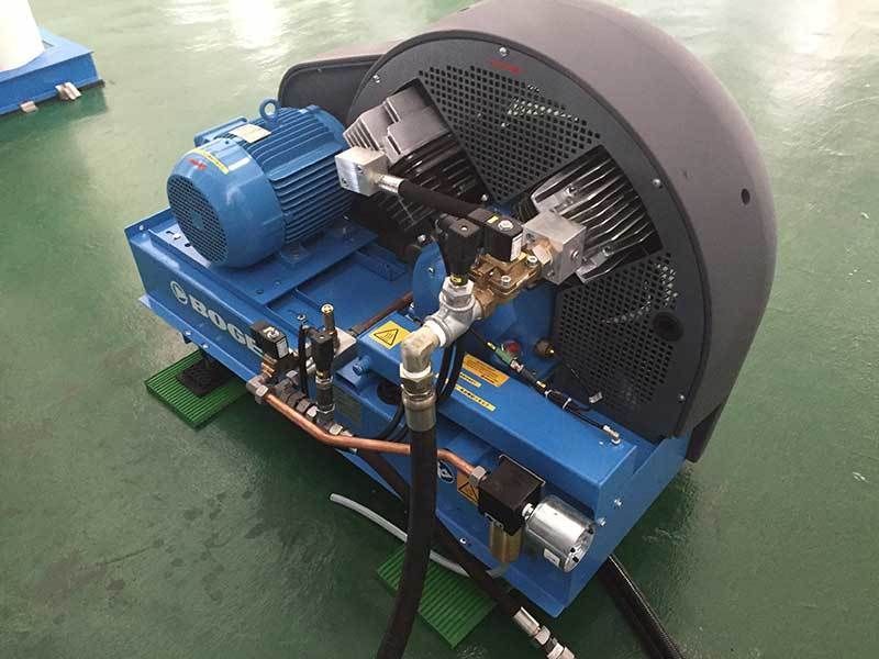 A blue machine with a motor attached to it is sitting on a green floor.