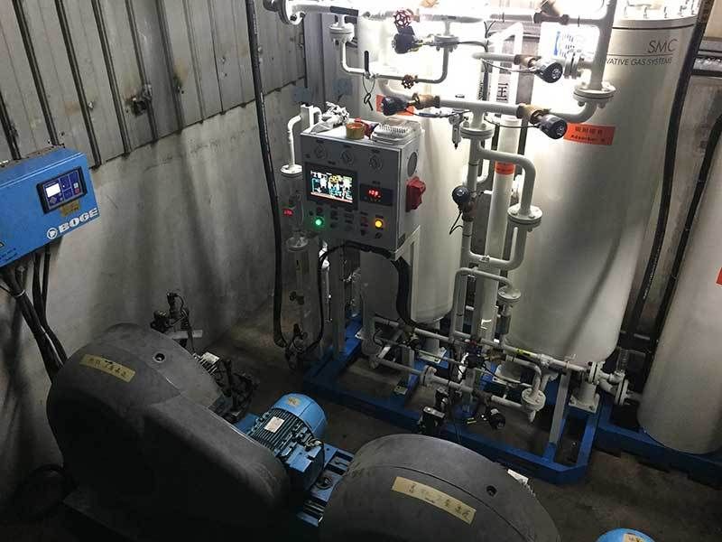 A room with a lot of pipes and a control panel.