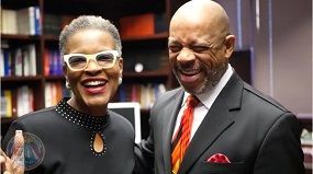 A man and a woman are posing for a picture in a library.