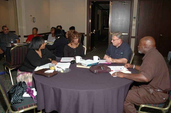 A group of people are sitting around a table talking