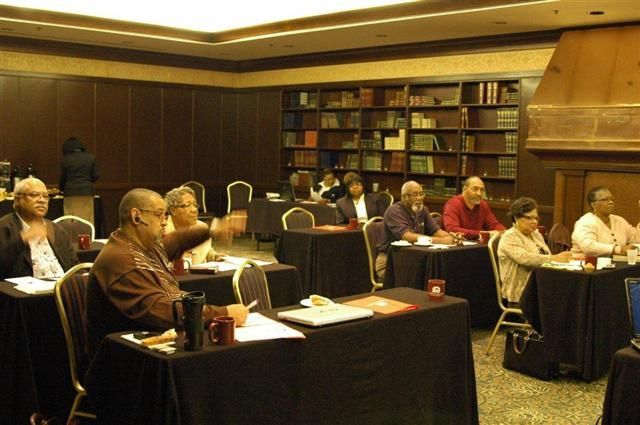 A group of people are sitting at tables in a library