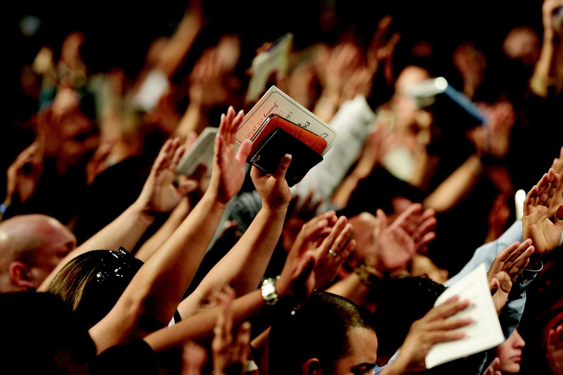 A crowd of people raising their hands in the air
