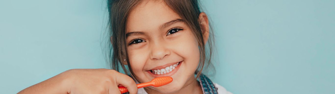 smiling kid brushing teeth