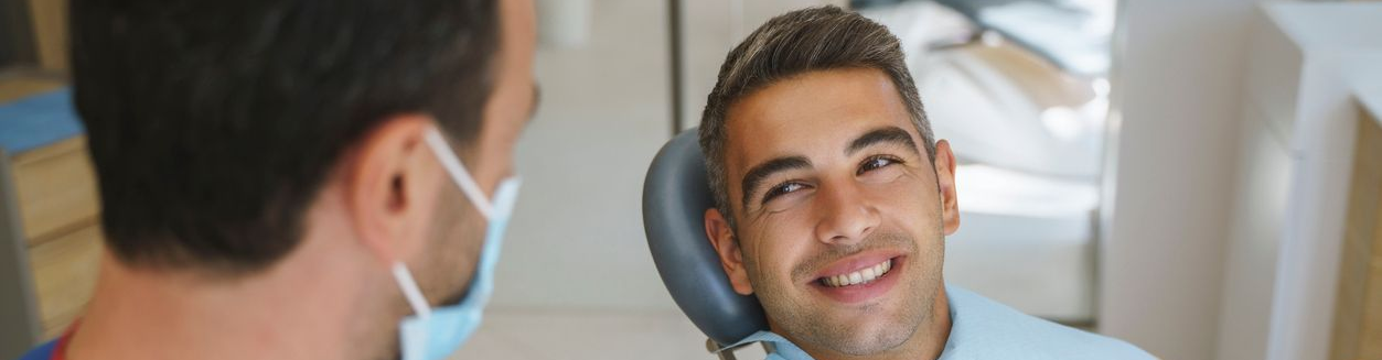 Two smiling women looking at a smart tablet in a dental office