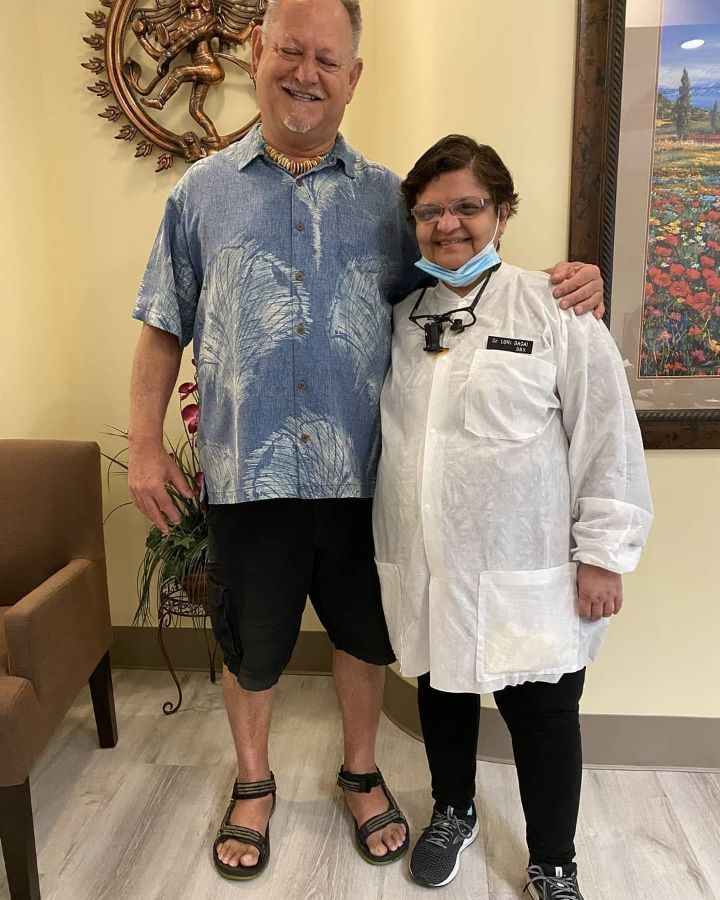 A man and a woman are posing for a picture in a waiting room.