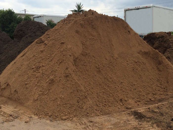 Large pile of brown mulch, possibly for gardening or landscaping, outdoors.