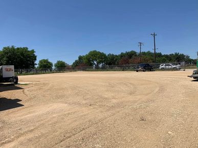 A truck is parked in the middle of a dirt field.