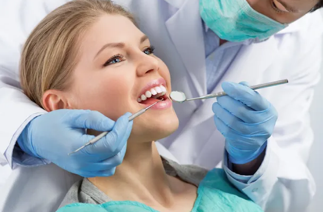 A woman is having her teeth examined by a dentist.