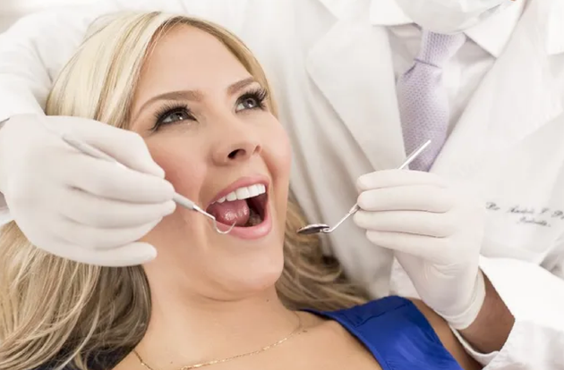 A woman is getting her teeth examined by a dentist.