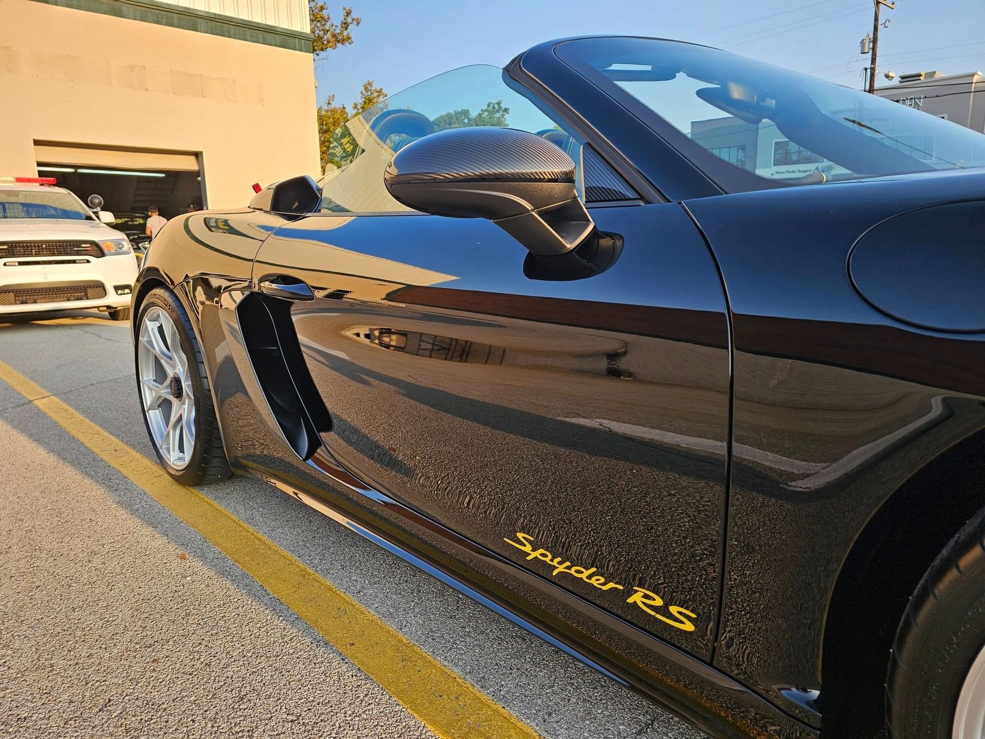 The interior of a BMW car with tan leather seats, a black dashboard, and a disposable paper floor mat on the driver's seat.