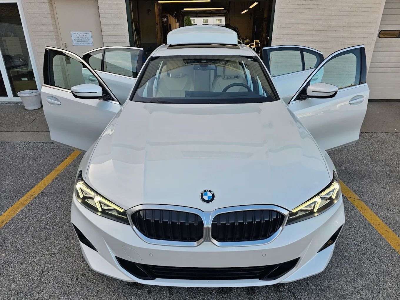 Low-angle view of the rear of a shiny red car raised on a service lift, highlighting the exhaust and wheel.