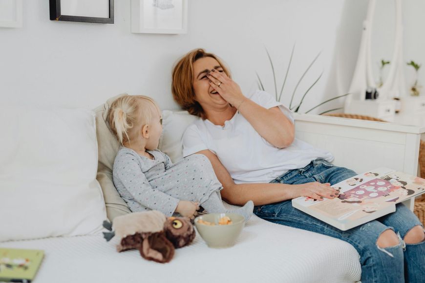 A woman and a child are sitting on a couch.