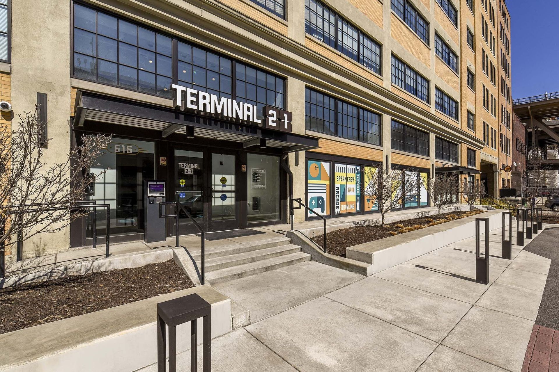 Exterior view of a brick apartment building with a glass entrance and stairs labeled Terminal 21.