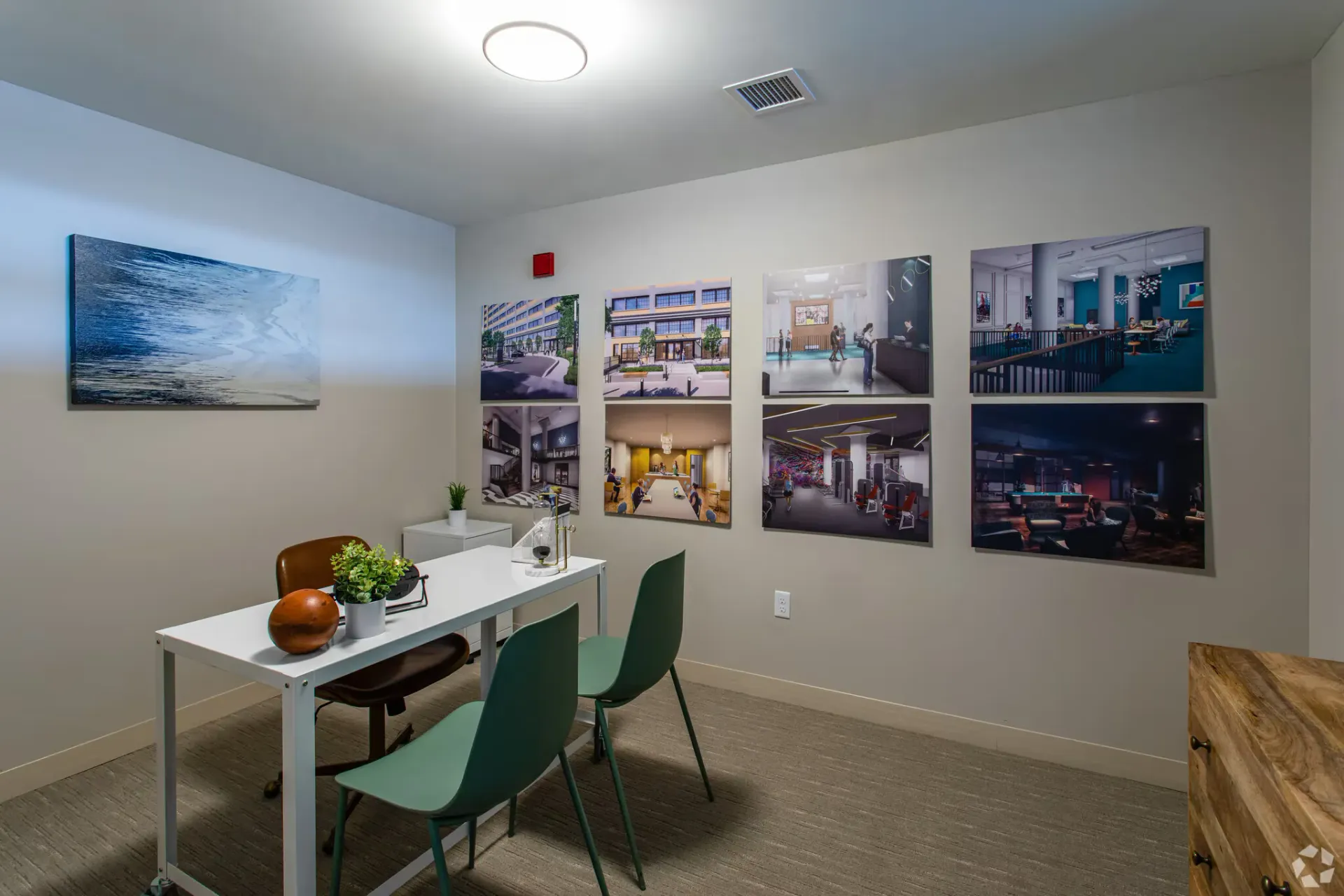 Leasing office with white desk, plants, and wall of property images at Terminal 21, a premier apartment community in Downtown Pittsburgh, Pennsylvania.