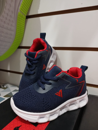 Zapatillas deportivas azules y verdes con suelas blancas en exposición.