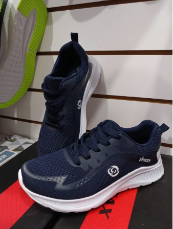 Zapatillas blancas con detalles en negro exhibidas en un estante, con otro par visible en el fondo.