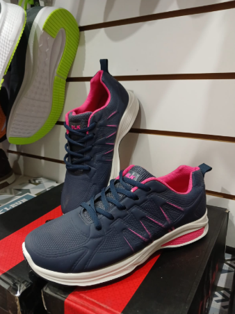 Zapatillas deportivas negras con suelas blancas en un estante de exhibición.