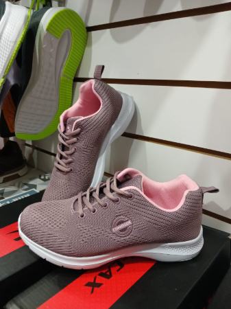 Zapatillas deportivas color malva con forro rosa y suela blanca, en exposición.