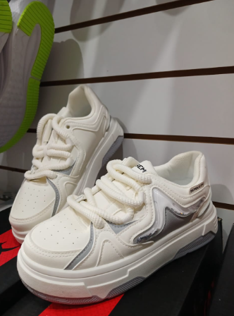 Zapatillas blancas de plataforma con cordones gruesos y detalles plateados.