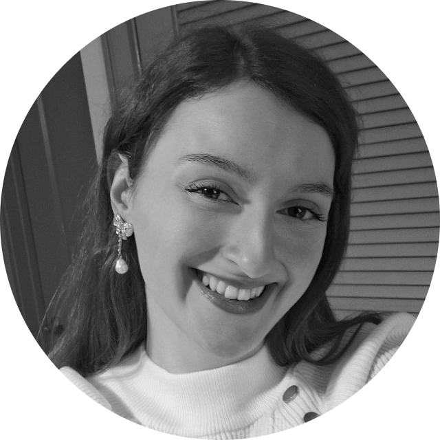 Smiling woman with dark hair and earrings, looking at the camera.