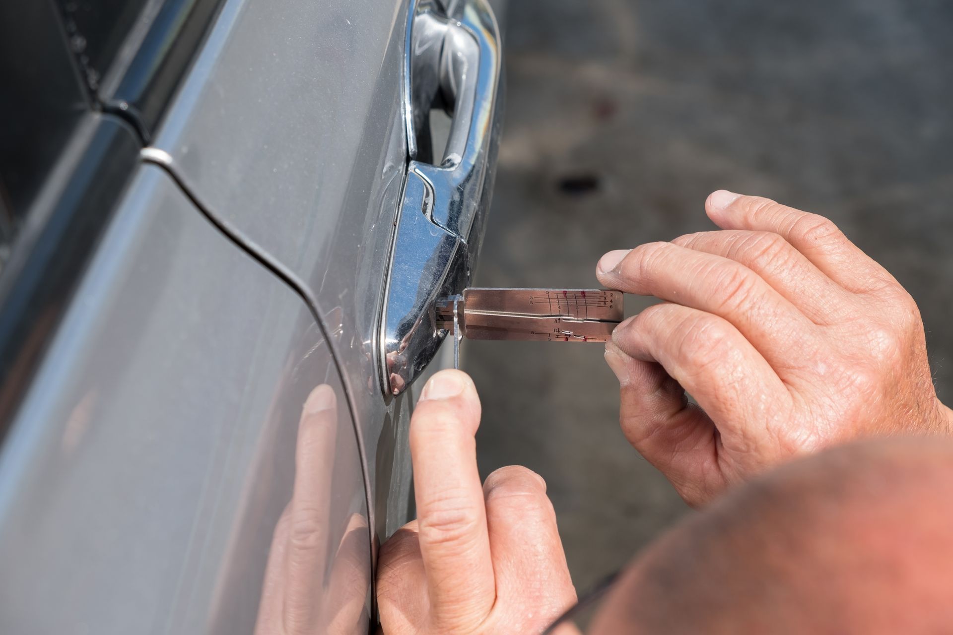 A man is using a key to open a car door.